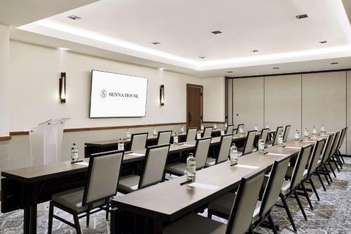 a conference room with tables and chairs and a whiteboard at Senna House Hotel Scottsdale, Curio Collection By Hilton in Scottsdale