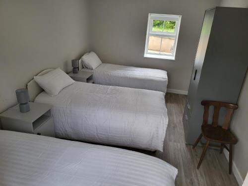 Pokój z 2 łóżkami, krzesłem i oknem w obiekcie Mountain Stream House 