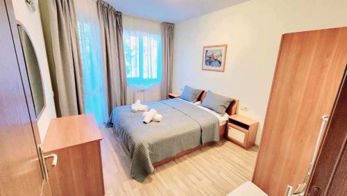 a bedroom with a bed with two stuffed animals on it at Arboro Royal Plaza in Borovets