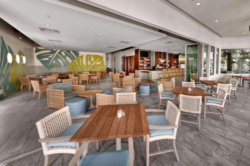 a restaurant with wooden tables and chairs at Hotel MDR Marina del Rey- a DoubleTree by Hilton in Los Angeles