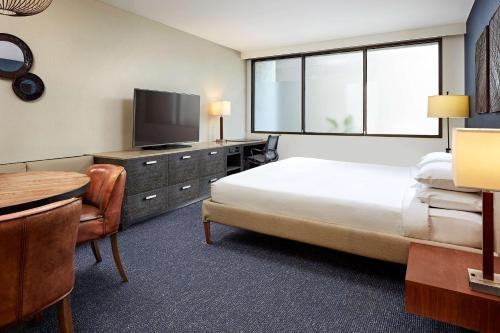 a hotel room with a bed and a tv and a table at Hotel MDR Marina del Rey- a DoubleTree by Hilton in Los Angeles