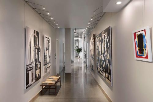 a hallway with framed art on the walls at Tapestry By Hilton The Fort Sutter Hotel Sacramento, Ca in Sacramento