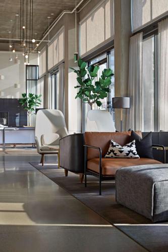 a living room with a couch and two chairs at Tapestry By Hilton The Fort Sutter Hotel Sacramento, Ca in Sacramento
