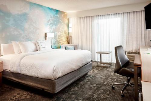 a bedroom with a bed and a desk and a chair at Courtyard Cincinnati Airport South/Florence in Florence