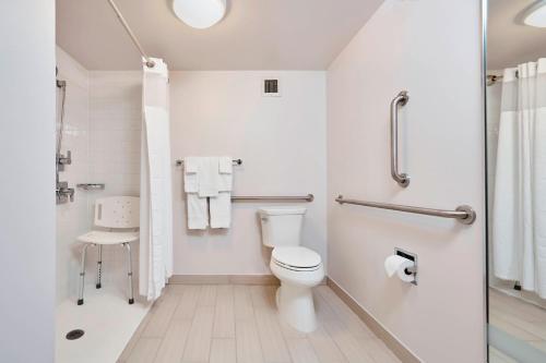a white bathroom with a toilet and a shower at Courtyard Cincinnati Airport South/Florence in Florence