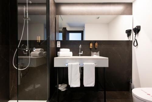 a bathroom with a sink and a shower at Hotel Maroa Vigo in Vigo