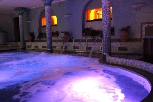a jacuzzi tub in a room with columns at Casanova - Wellness Center La Grotta Etrusca in San Quirico dʼOrcia