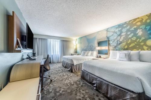a hotel room with two beds and a painting on the wall at Courtyard Dallas DFW Airport South/Irving in Irving