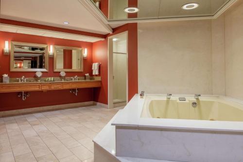 a large bathroom with a tub and two sinks at Hilton Bellevue in Bellevue