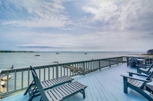 a deck with benches and a view of the water at Serene Mattapoisett Home with Private Beach Access! in Mattapoisett