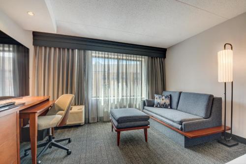 a living room with a couch and a desk and a chair at Courtyard Cincinnati North at Union Centre in West Chester