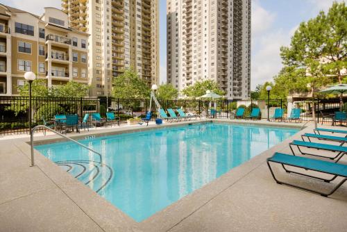 una gran piscina con sillas azules y edificios en Hampton Inn Atlanta Perimeter Center, en Atlanta