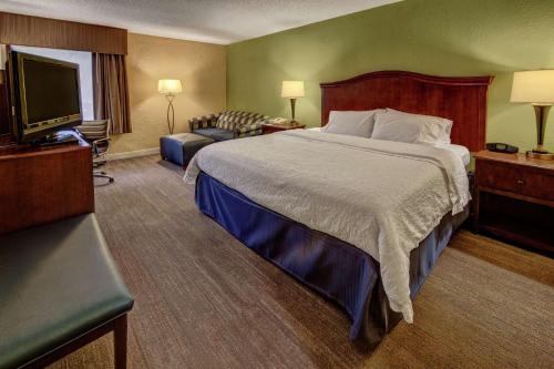 a hotel room with a bed and a flat screen tv at Hampton Inn Raleigh Cary in Cary