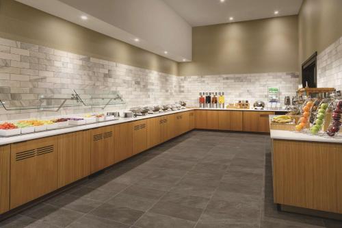 a large kitchen with wooden cabinets and food on display at DoubleTree by Hilton Colorado Springs in Colorado Springs