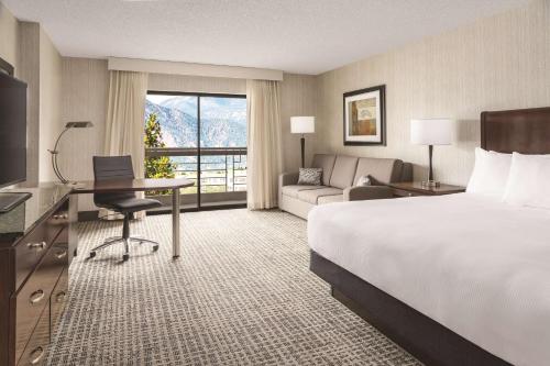 DoubleTree by Hilton Colorado Springs في كولورادو سبرينغز: غرفة الفندق بسرير ومكتب واريكة