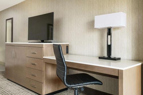 a desk with a television and a chair in a room at DoubleTree by Hilton Colorado Springs in Colorado Springs