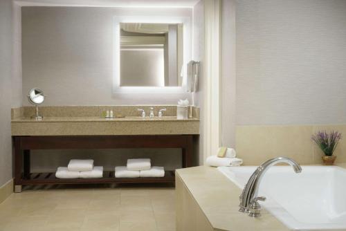 a bathroom with a sink and a bath tub at DoubleTree by Hilton Colorado Springs in Colorado Springs