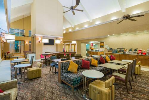 a restaurant with tables and chairs and a bar at Homewood Suites by Hilton Houston-Clear Lake in Webster