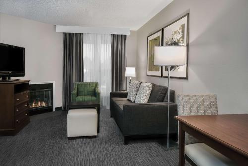 a living room with a couch and a chair and a television at Homewood Suites by Hilton Houston-Clear Lake in Webster