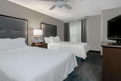 a hotel room with two beds and a flat screen tv at Homewood Suites by Hilton Houston-Clear Lake in Webster