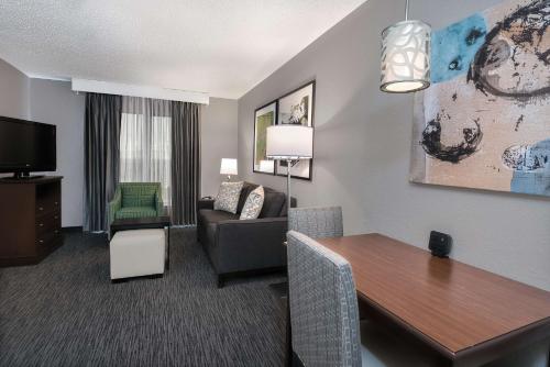 a living room with a table and a couch and a room at Homewood Suites by Hilton Houston-Clear Lake in Webster