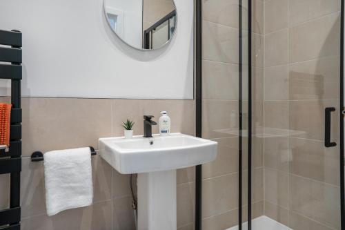 a bathroom with a sink and a shower at Isimi Burnley 3 bedroom modern house free parking in Burnley