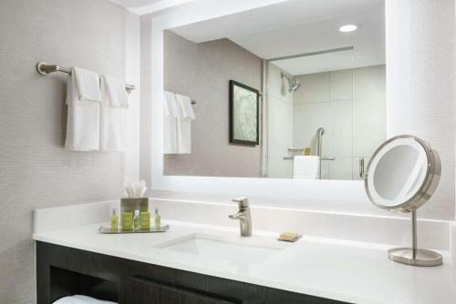 a bathroom with a sink and a mirror at DoubleTree by Hilton Orlando Airport Hotel in Orlando