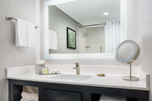 a bathroom with a sink and a mirror at DoubleTree by Hilton Orlando Airport Hotel in Orlando