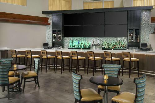 a bar in a restaurant with chairs and tables at DoubleTree by Hilton Orlando Airport Hotel in Orlando