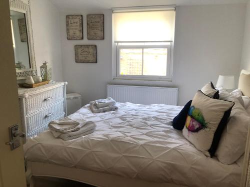 a bedroom with a bed with towels on it at Dinky cottage in Brightlingsea