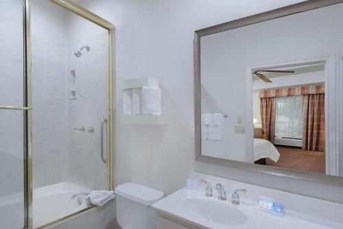 a bathroom with a shower and a sink and a mirror at Hilton Garden Inn McAllen Airport in McAllen