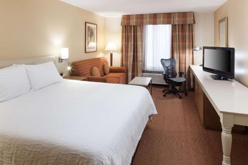 a hotel room with a bed and a desk with a computer at Hilton Garden Inn McAllen Airport in McAllen