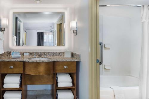 uma casa de banho com um lavatório, um espelho e um chuveiro em Homewood Suites Phoenix-Metro Center em Phoenix