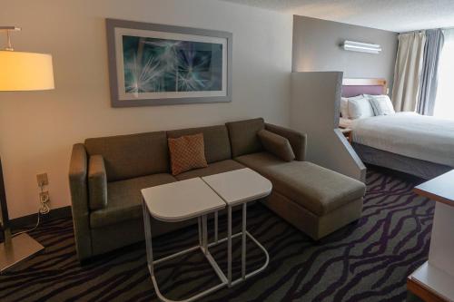 une chambre d'hôtel avec un canapé et un lit dans l'établissement SpringHill Suites by Marriott Savannah Midtown, à Savannah
