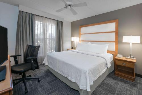 a hotel room with a bed and a desk and a chair at Homewood Suites Phoenix-Metro Center in Phoenix