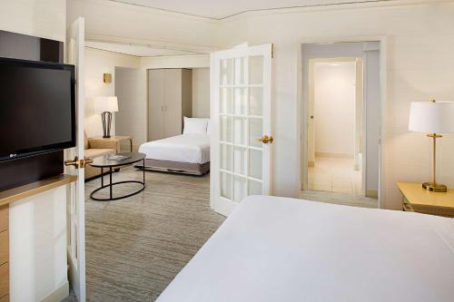 une chambre d'hôtel avec un lit et une télévision dans l'établissement Hilton Atlanta Perimeter Suites, à Atlanta