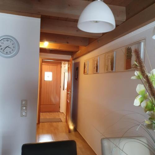 a hallway with a clock on the wall and a door at Haus Sonntal in Bodenmais