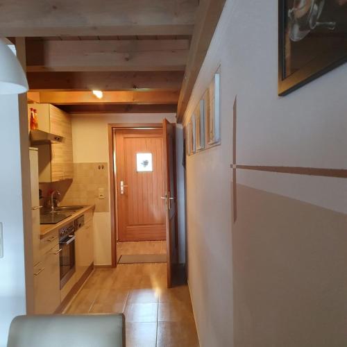 a kitchen with a hallway with a refrigerator and a door at Haus Sonntal in Bodenmais