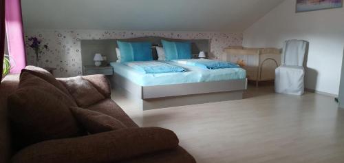een slaapkamer met een bed en een bank bij Haus Sonntal in Bodenmais