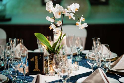 a table with glasses and a vase with white flowers at Hilton Garden Inn Exton-West Chester in Exton