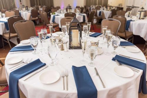 a table with white plates and glasses on it at Hilton Garden Inn Exton-West Chester in Exton