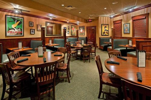 uma sala de jantar com mesas e cadeiras de madeira em Hilton Springfield em Springfield