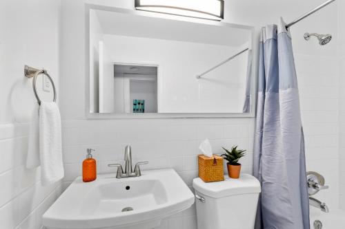 Baño blanco con lavabo y espejo en Lorna Leisure House - A, en Nashville