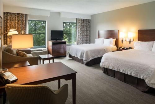 リトルロックにあるHampton Inn & Suites Little Rock-Downtownのベッド2台とデスクが備わるホテルルームです。