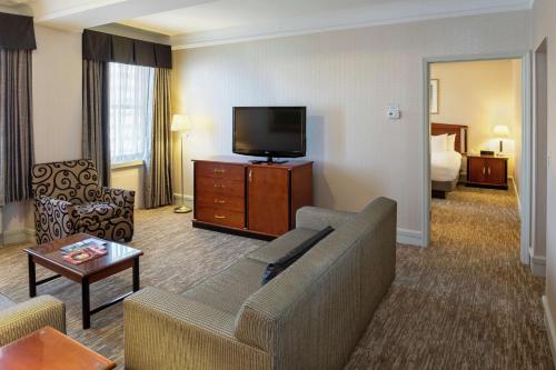 a living room with a couch and a flat screen tv at Hilton Cincinnati Netherland Plaza in Cincinnati