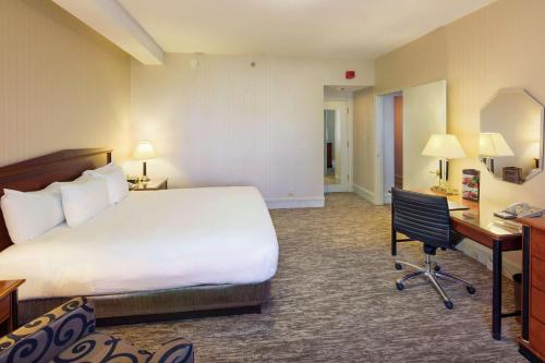 a hotel room with a bed and a desk at Hilton Cincinnati Netherland Plaza in Cincinnati