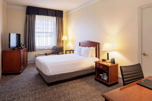 a hotel room with a bed and a desk at Hilton Cincinnati Netherland Plaza in Cincinnati