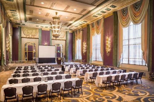 a large room with chairs and a screen in it at Hilton Cincinnati Netherland Plaza in Cincinnati