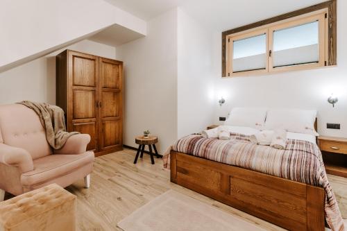 a bedroom with a bed and a chair and a window at Chata za wsią - Czorsztyn Lake, Kluszkowce Ski in Kluszkowce