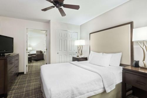 a bedroom with a white bed and a flat screen tv at Homewood Suites by Hilton Raleigh/Crabtree Valley in Raleigh